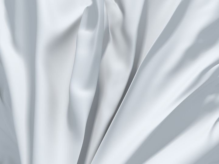 White fabric drapes elegantly with soft folds and shadows.