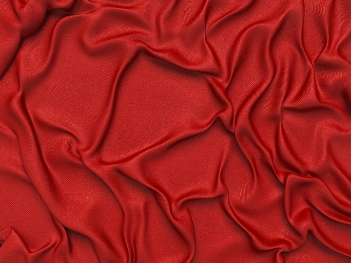 Red fabric drapes with soft folds and shadows, creating a rich, textured surface.