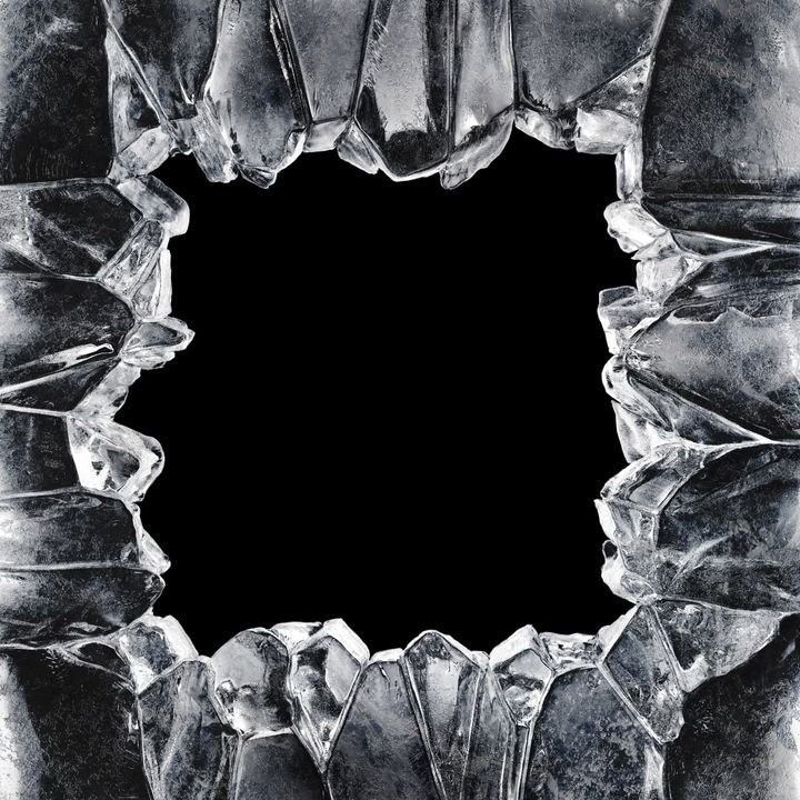 A shattered glass frame surrounds a black void, capturing the tension of broken transparency against darkness.
