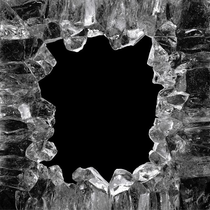 A jagged hole in a block of ice reveals a dark void behind it.