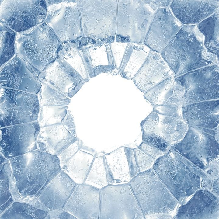 A close-up view shows a shattered ice surface with a central hole. The surrounding ice displays a complex, geometric pattern of fractured shards in shades of blue and white.
