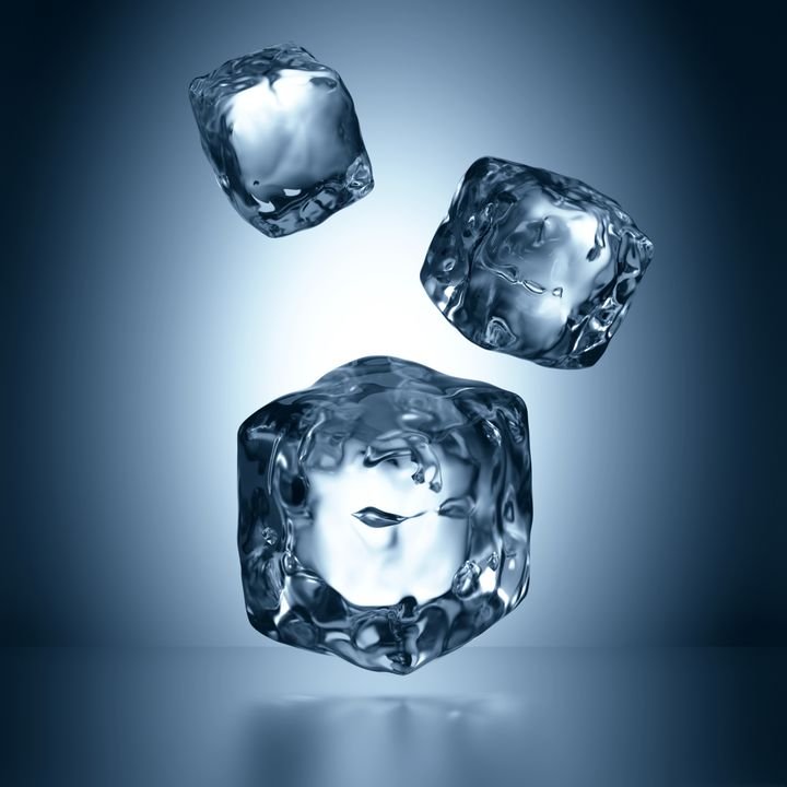 Three ice cubes float in mid-air against a blue gradient background, reflecting light with a glossy texture.