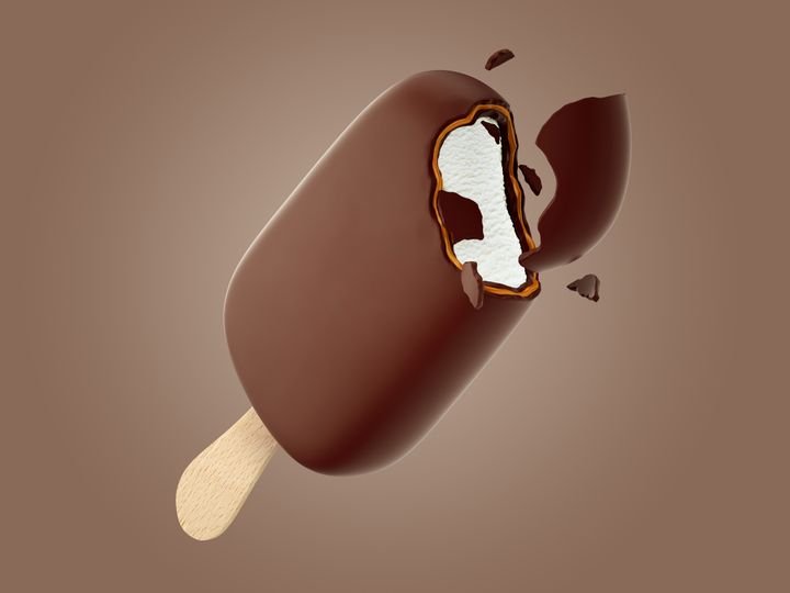 A bitten chocolate ice cream bar floats against a brown background, revealing creamy white filling.