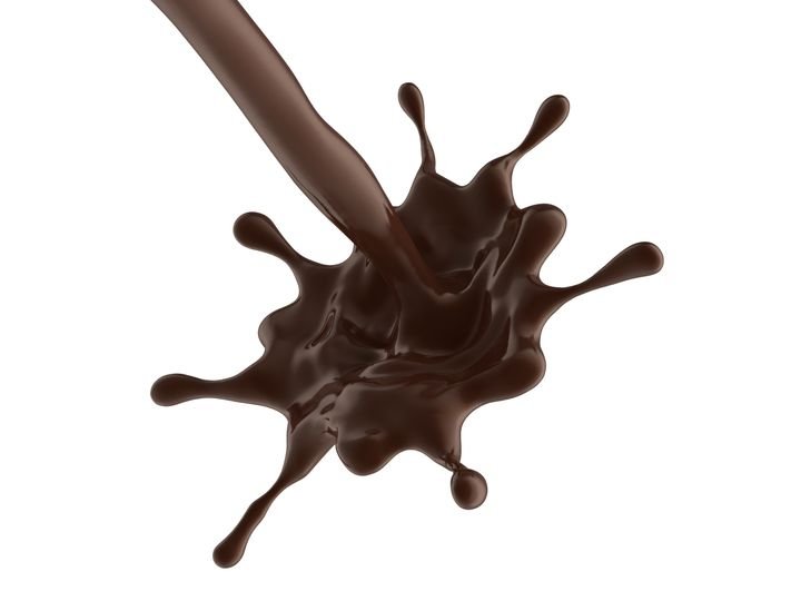 A stream of rich chocolate splashes dynamically against a stark white background, creating an artistic and appetizing visual.