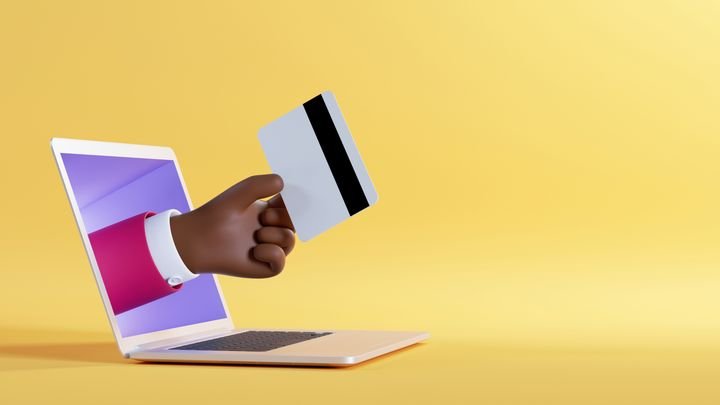 3d illustration. African cartoon character hand sticking out the laptop screen, holding plastic credit card. Business financial clip art isolated on yellow background. Internet banking service
