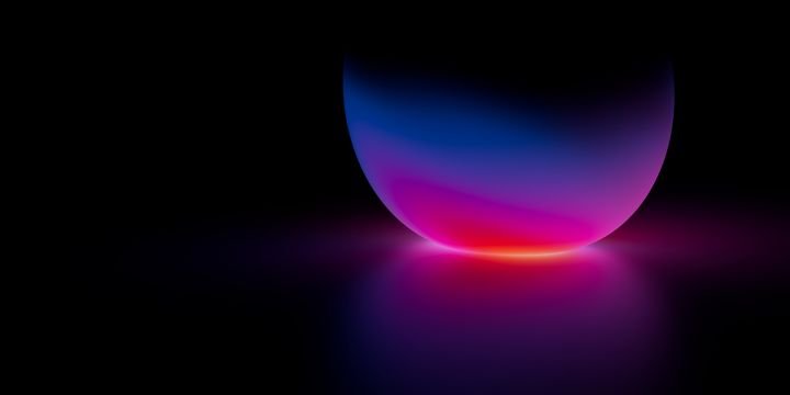 Neon glowing sphere with pink and blue gradient light reflection on black surface, futuristic abstract background for stock visuals and design projects.