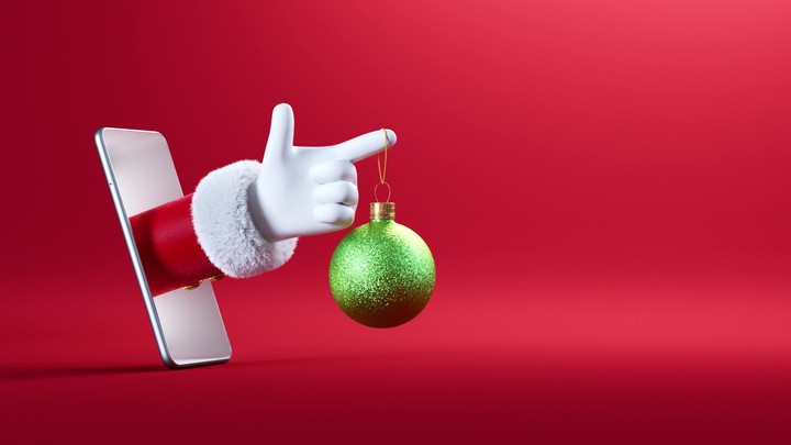 3d animation. Cartoon character Santa Claus hand sticking out the smart phone screen and holds green hanging glass ball ornament. Christmas festive banner with red background