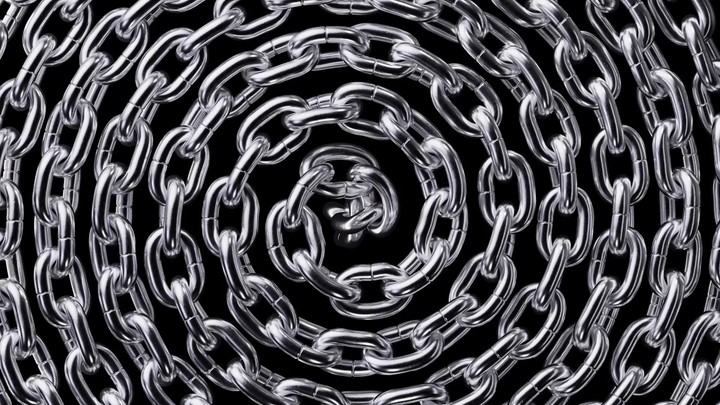 looped 3d animation of spiraling silver chain macro isolated on black background