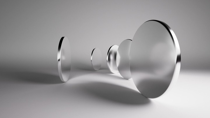 Looping 3d animation. Abstract minimalist background with shiny silver geometric shapes. Round mirrors spinning and rotating inside the empty white room, casting shadows under the studio lights