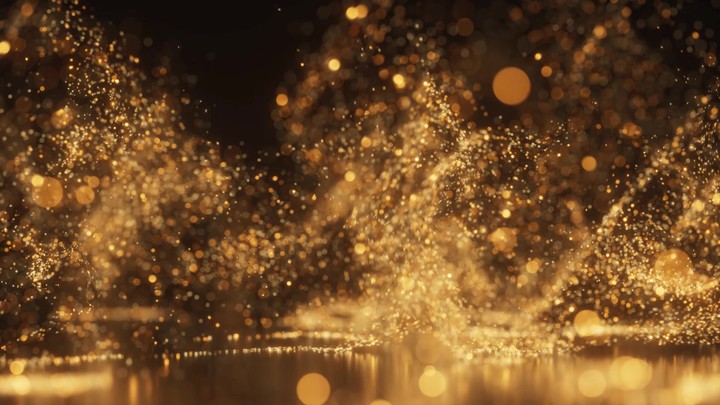 Abstract shimmering background with golden glitter and soft focus bokeh lights swirling in slow motion.